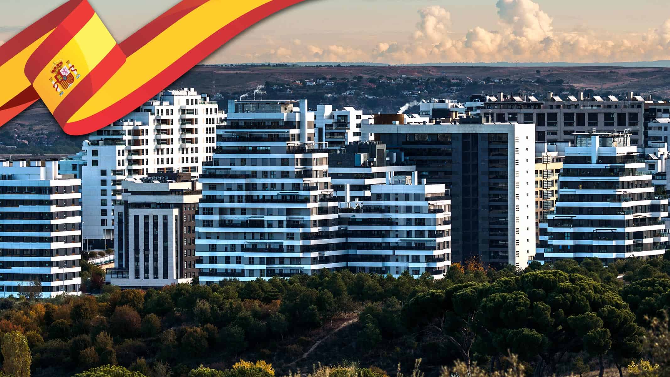 Edificios modernos en España con la bandera española en la esquina, representando el mercado de alquiler de viviendas en 2025.