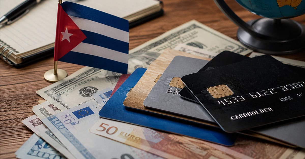 Persona revisa documentos financieros y una laptop como referencia a cuentas bancarias en divisas fuera de Cuba