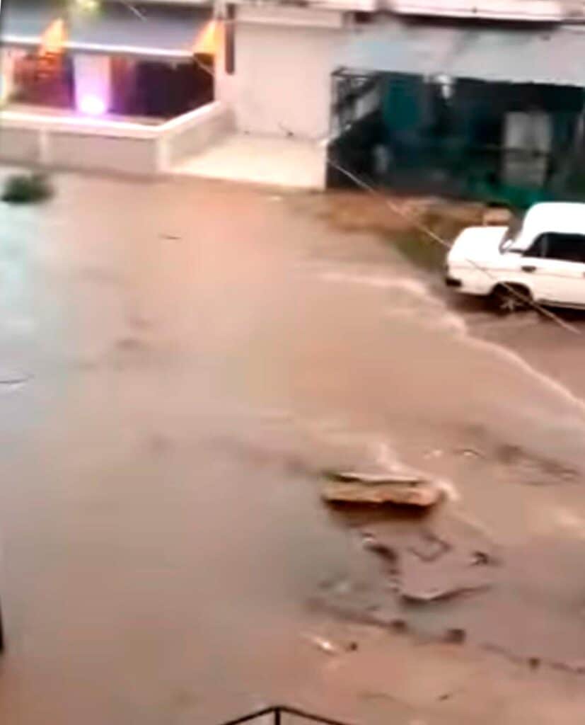 Calle Inundada con Auto Blanco