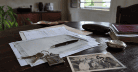 Documentos legales, llaves de una vivienda y objetos personales sobre una mesa durante un procedimiento de herencia en Cuba.