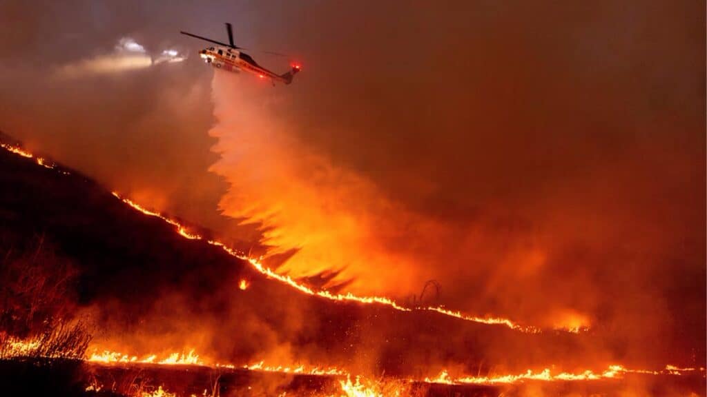 Helicóptero de Bombero Dejando Caer Agua Sobre Zona de Vegetación Incendiada