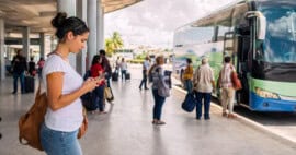 Ómnibus interprovincial en Cuba mientras una persona realiza una reserva desde el extranjero mediante una plataforma digital.