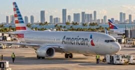 Avión de American Airlines en la plataforma de un aeropuerto internacional durante una mañana soleada.