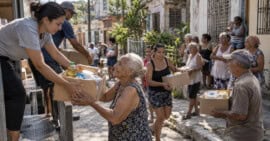 Voluntarios entregan cajas con alimentos y productos básicos a adultos mayores y familias vulnerables en Cuba.