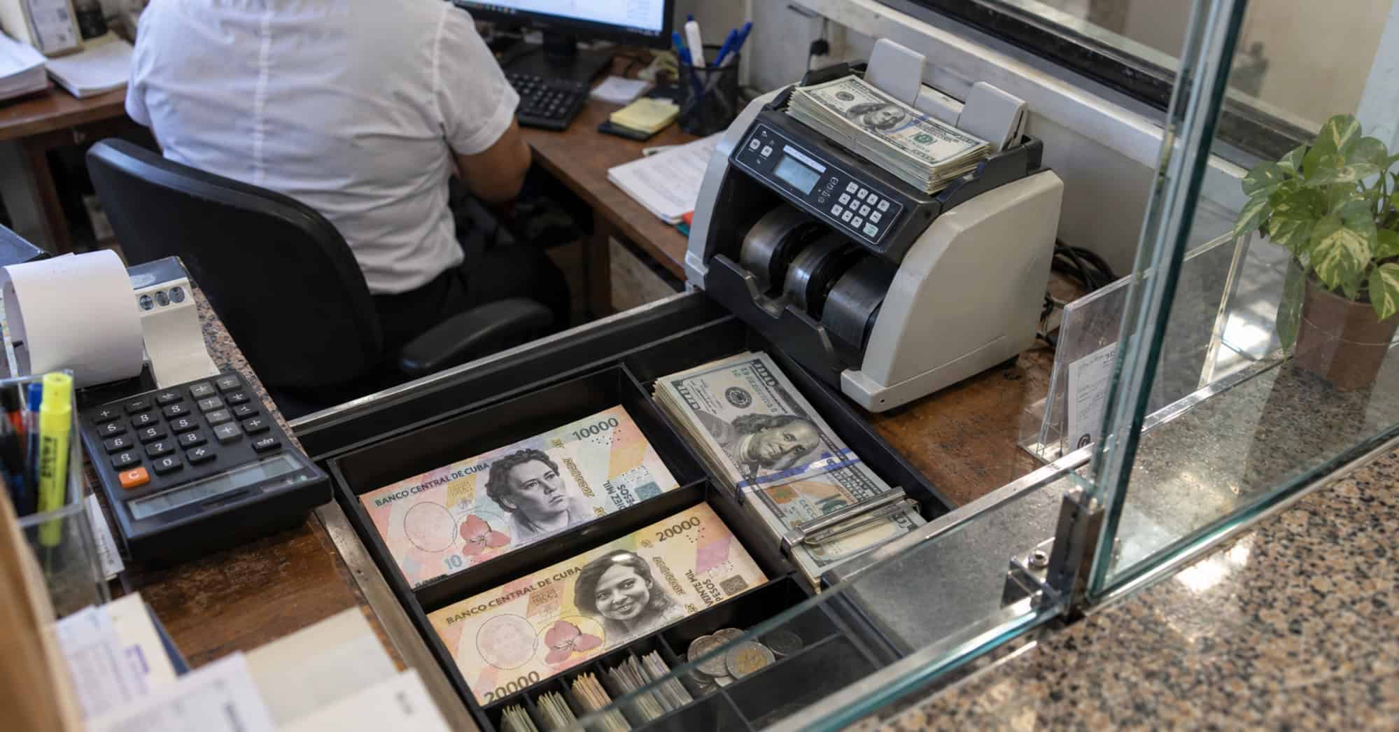 Casa de cambio privada en Cuba con dólares y billetes cubanos organizados en una gaveta