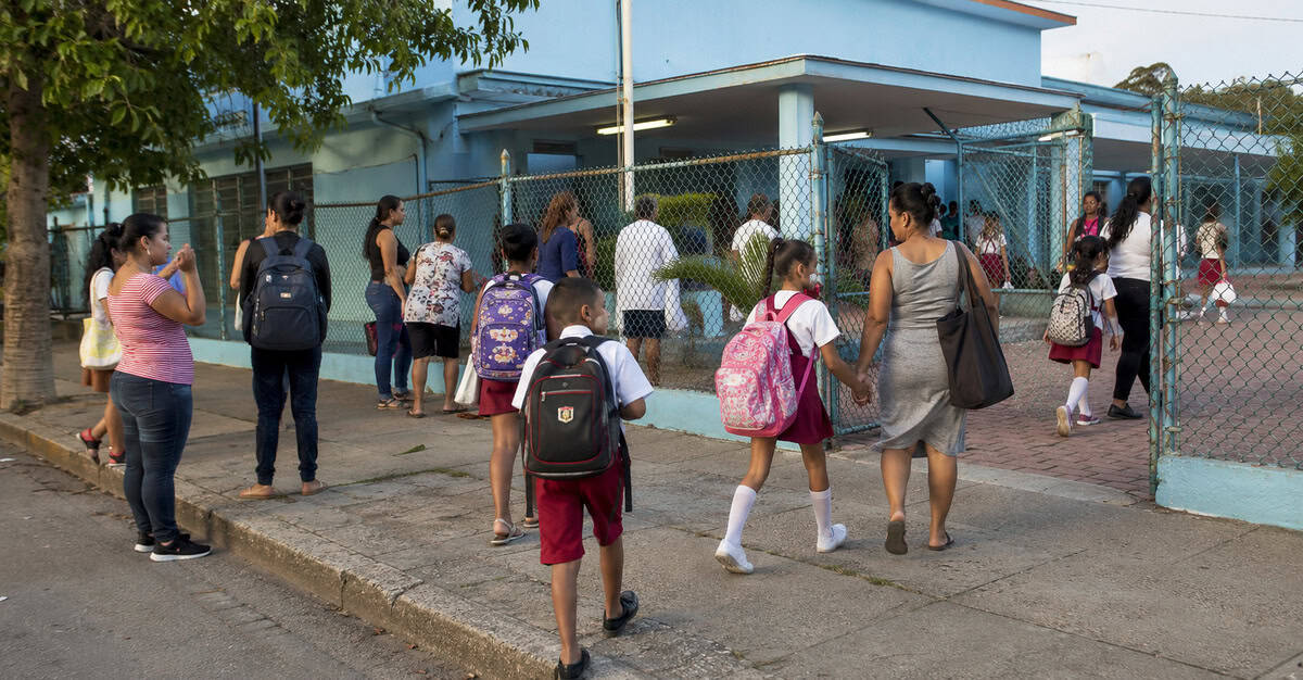 Estudiantes cubanos llegan acompañados por sus familiares a una escuela pública al comenzar el curso escolar.