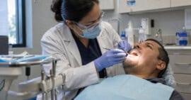 Dentista examina a un paciente adulto durante una consulta en una clínica comunitaria de Estados Unidos.