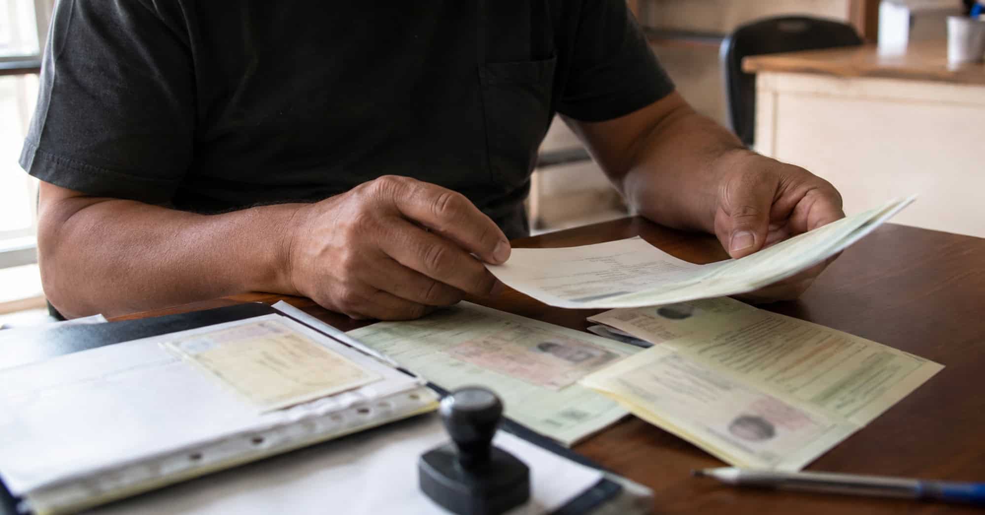 Ciudadano cubano revisa documentos relacionados con los trámites de identidad personal y domicilio.