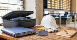 Maleta, pasaporte y herramientas de trabajo que representan la búsqueda de empleo legal en el extranjero para cubanos.