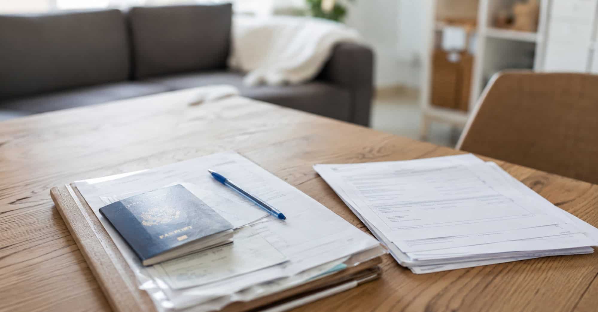 Documentos y pasaporte sobre una mesa para realizar trámites de residencia en España
