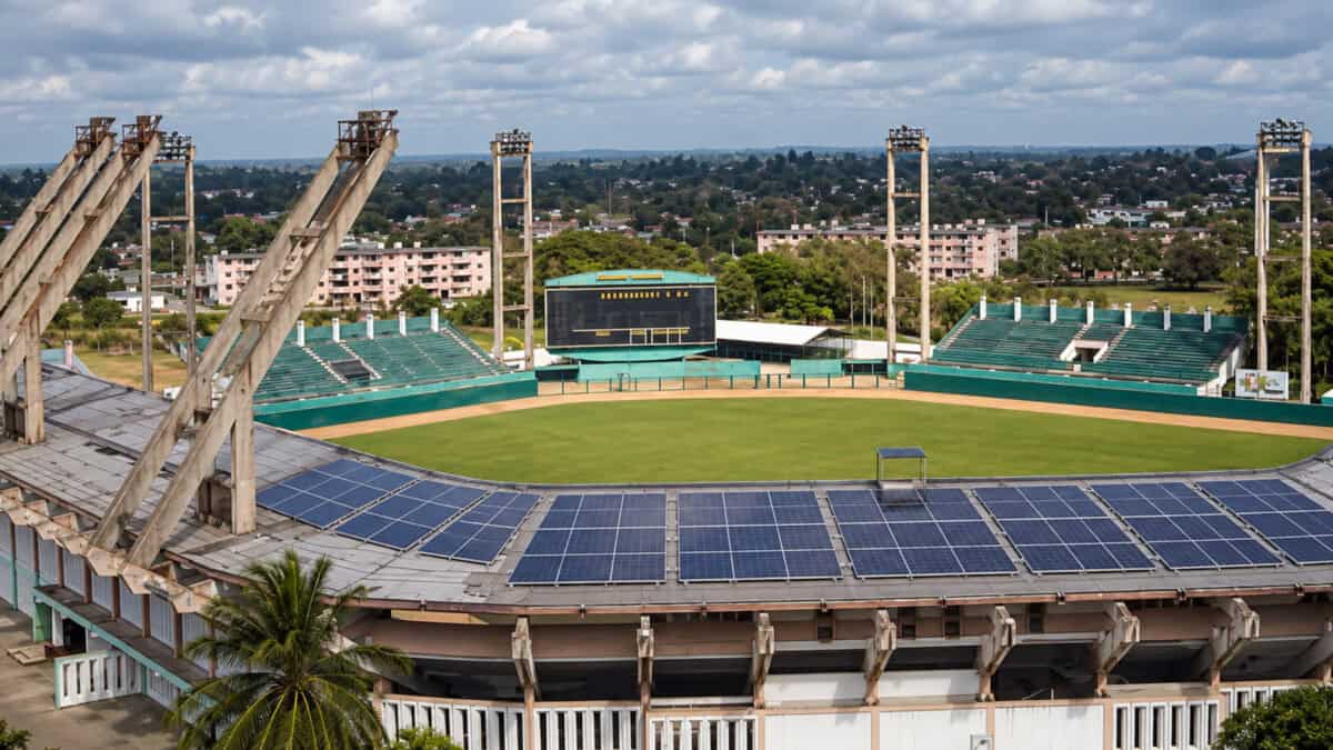 Vista elevada del estadio Sandino de Santa Clara con paneles solares añadidos digitalmente sobre la cubierta de los graderíos.