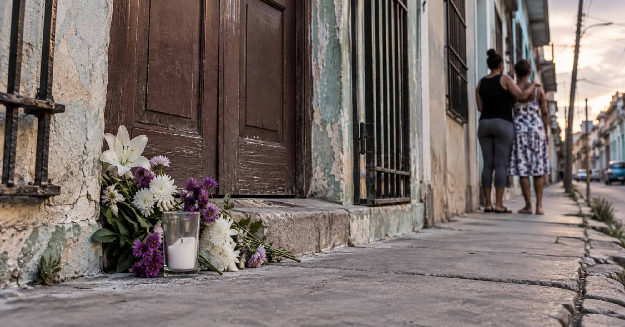 Flores colocadas frente a una vivienda cubana como símbolo de duelo por las víctimas de feminicidio en Cuba.