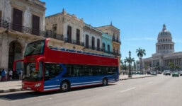 Autobús turístico de dos pisos recorriendo una avenida de La Habana, en una imagen representativa del turismo en Cuba y la futura apertura a guías turísticos privados.