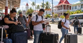 Viajeros con maletas y documentos en una escena editorial ambientada en Georgetown, Guyana.
