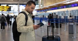 Persona cubana con pasaporte y equipaje en un aeropuerto internacional antes de emigrar por motivos laborales.