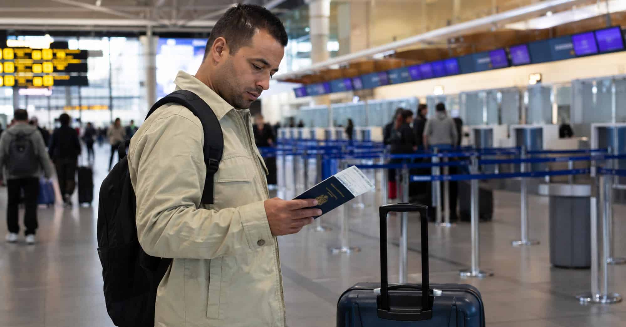 Persona cubana con pasaporte y equipaje en un aeropuerto internacional antes de emigrar por motivos laborales.