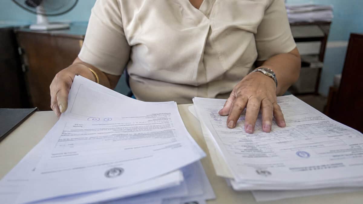 Persona organizando documentos para solicitar un certificado de matrimonio en Cuba