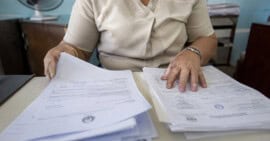 Persona organizando documentos para solicitar un certificado de matrimonio en Cuba