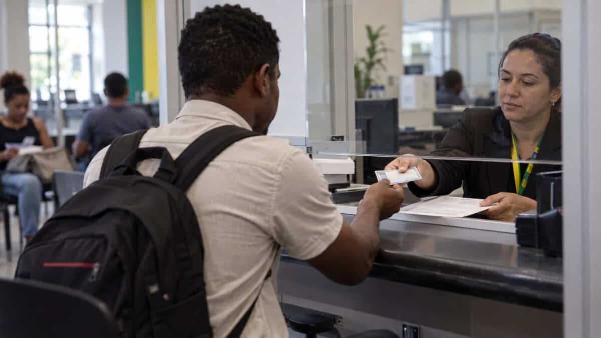 Persona recibe documentación durante un trámite migratorio relacionado con el trabajo en Brasil