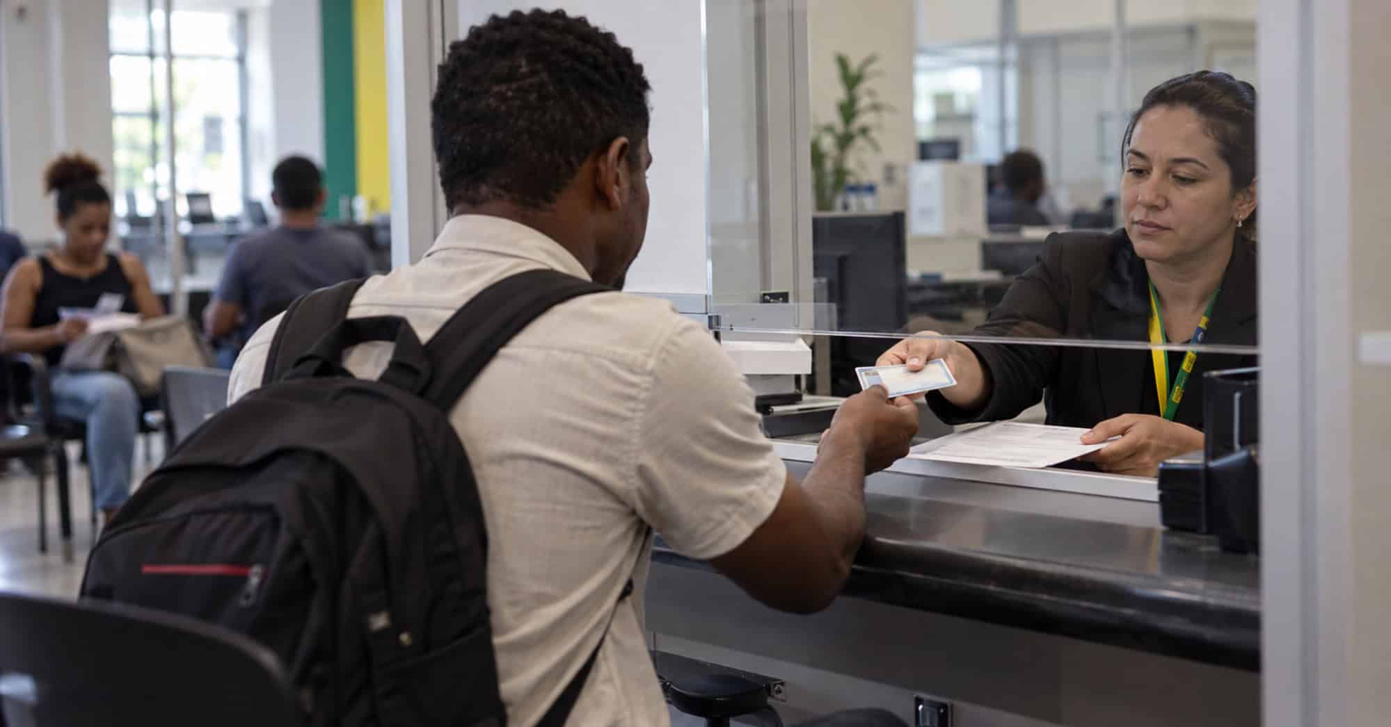 Persona recibe documentación durante un trámite migratorio relacionado con el trabajo en Brasil