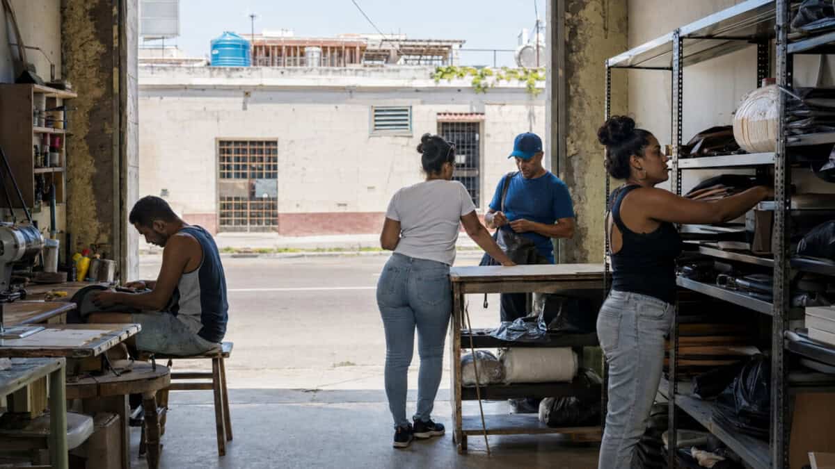 Propietarios y trabajadores cubanos realizan actividades comerciales en una pequeña empresa privada urbana.