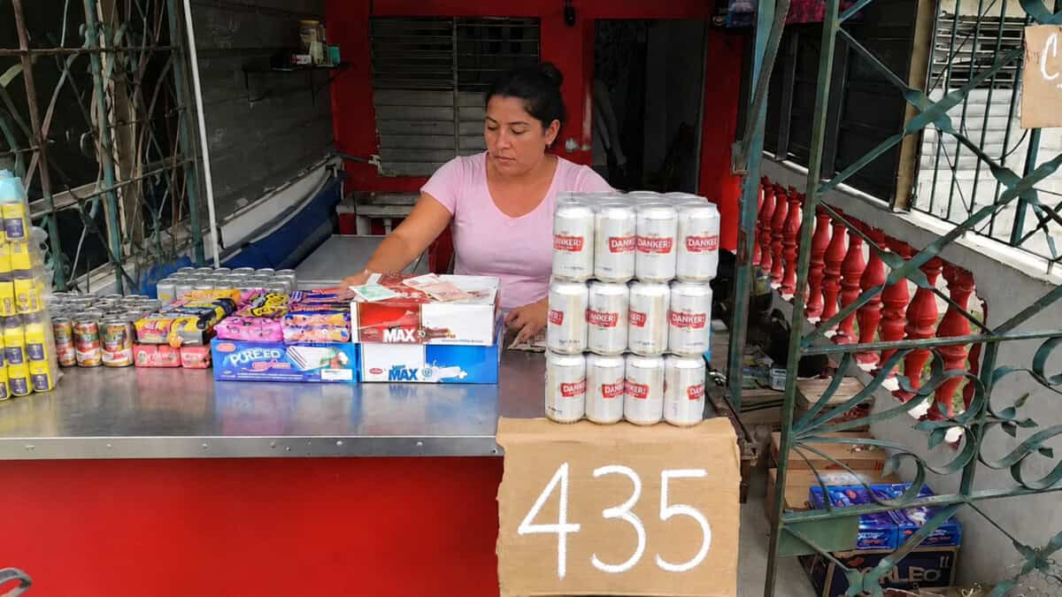 Mujer atiende una mipyme cubana con productos a la venta y un cartel de precio de 435 pesos