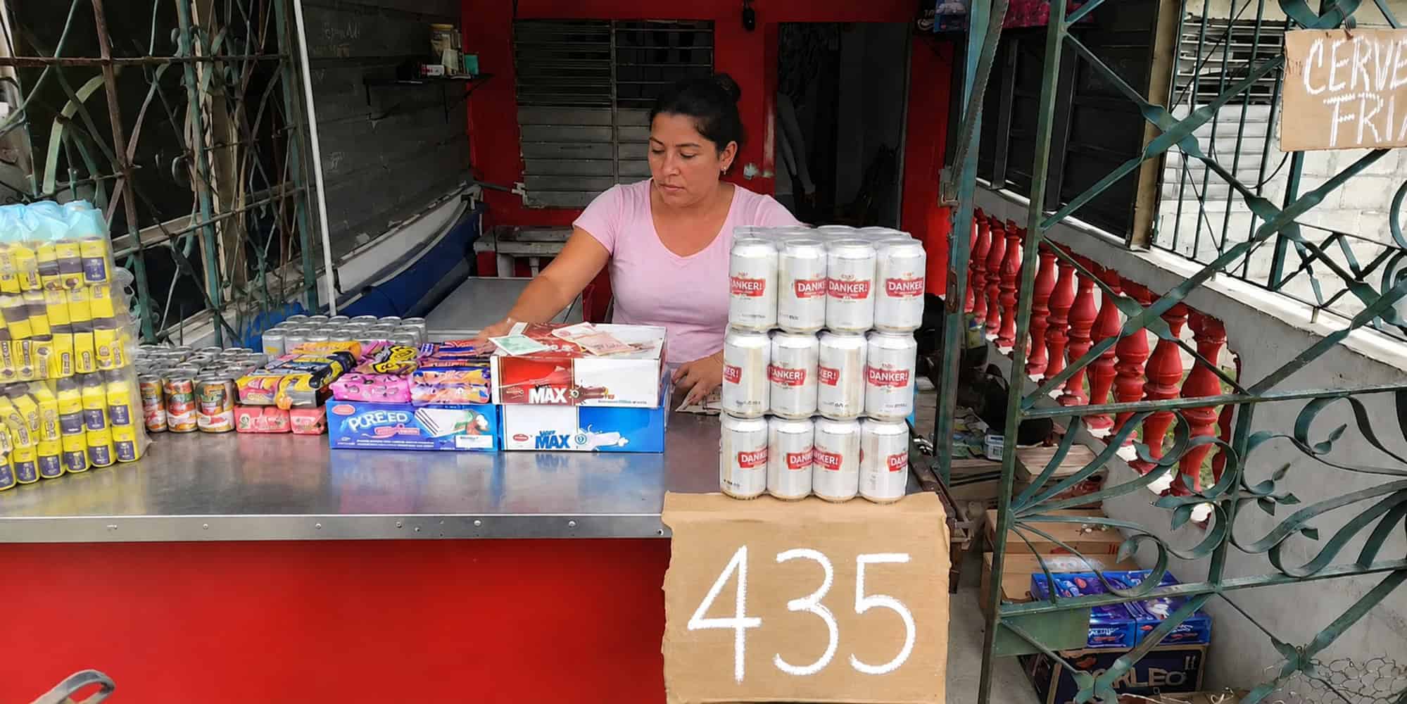 Mujer atiende una mipyme cubana con productos a la venta y un cartel de precio de 435 pesos