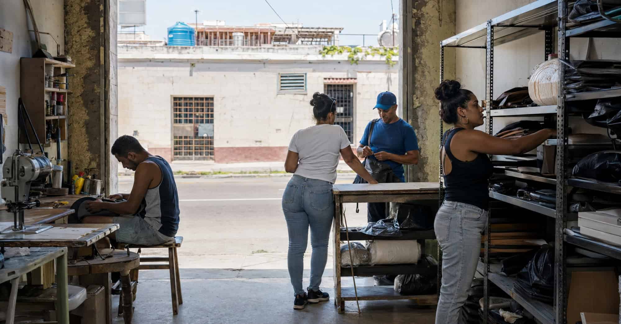 Propietarios y trabajadores cubanos realizan actividades comerciales en una pequeña empresa privada urbana.