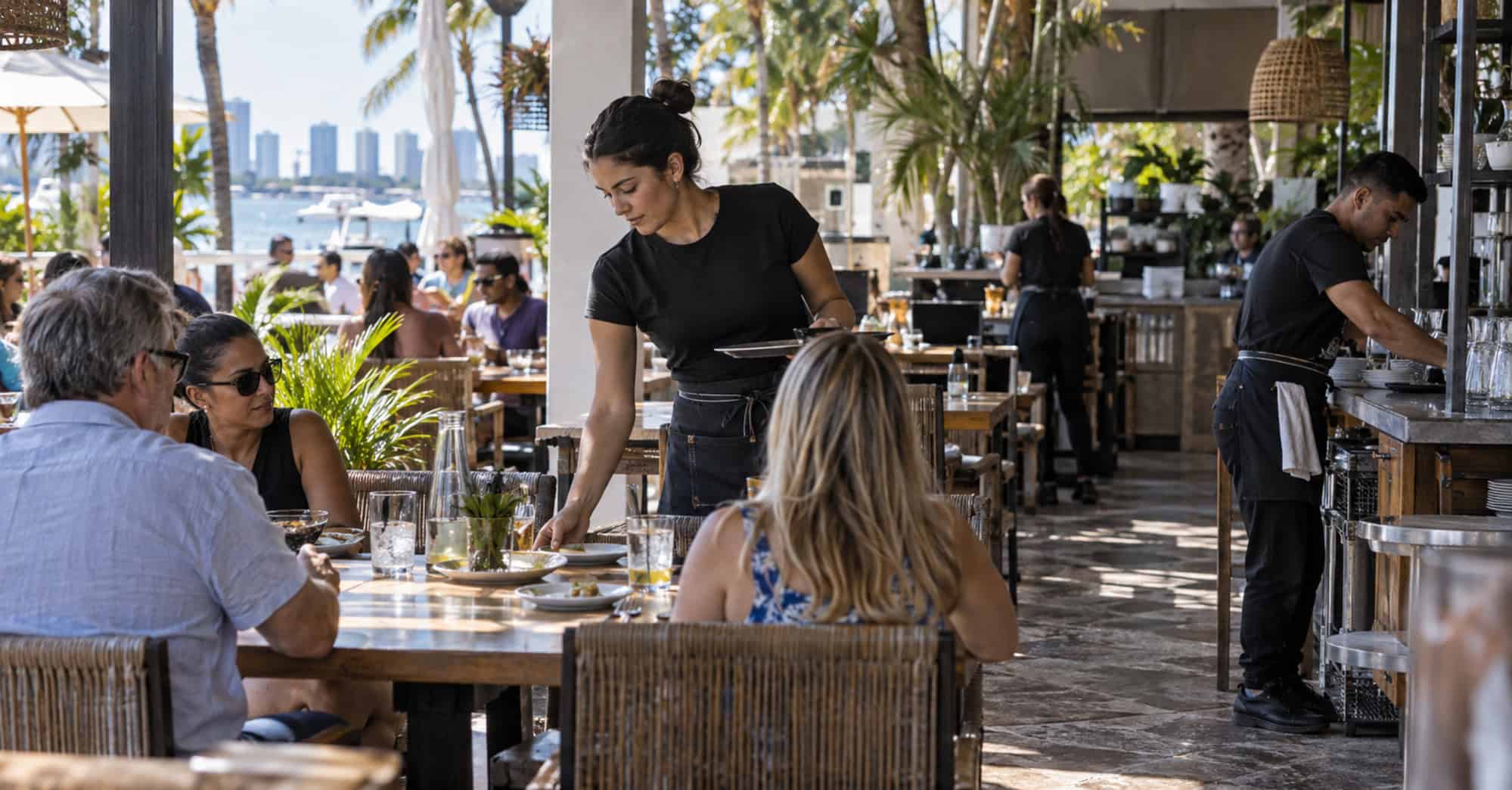 Trabajadores atienden un restaurante del sur de Florida antes del aumento del salario mínimo a 15 dólares por hora