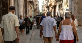 Vista de una calle en Cuba con personas mayores y pocos jóvenes, ilustrando el envejecimiento demográfico de la población cubana.
