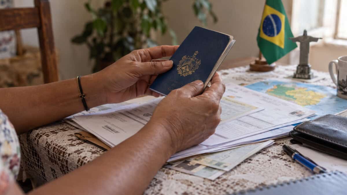 Persona sostiene un pasaporte sobre documentos para solicitar residencia en Brasil