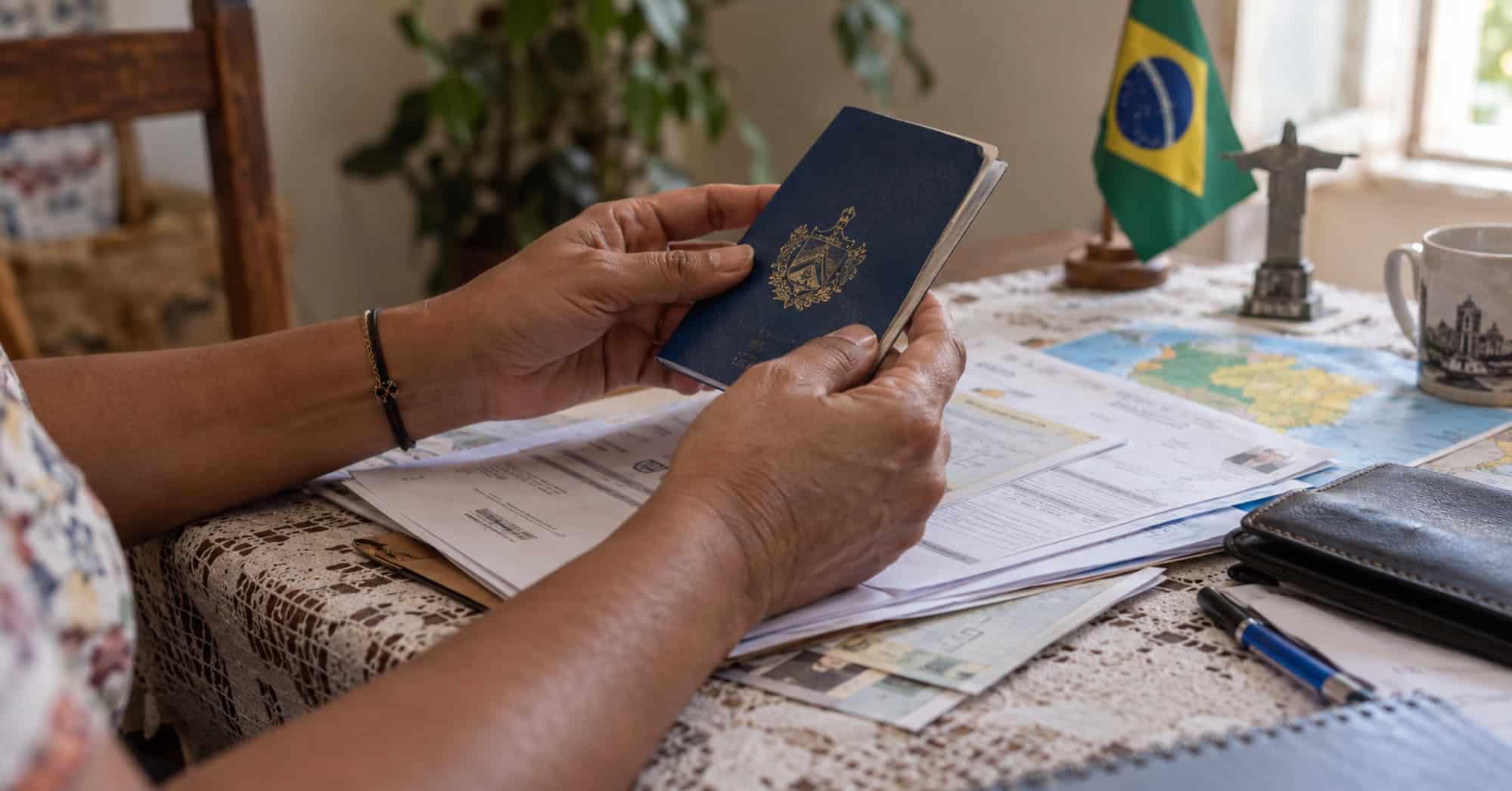 Persona sostiene un pasaporte sobre documentos para solicitar residencia en Brasil