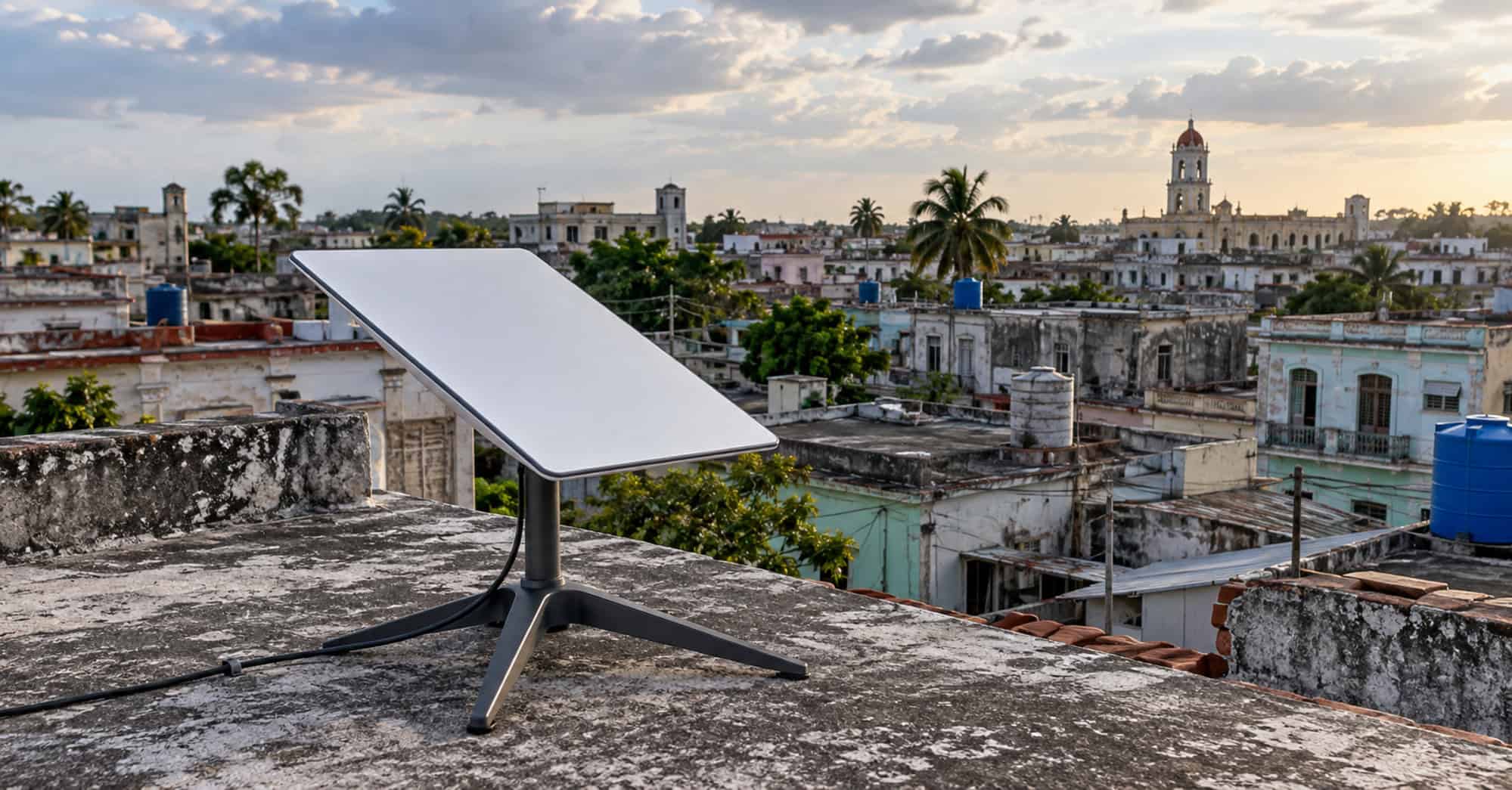 Antena de internet satelital Starlink sobre una azotea de hormigón, con viviendas cubanas al fondo.