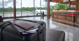 Maleta y documentos de viaje en una terminal aérea de Surinam