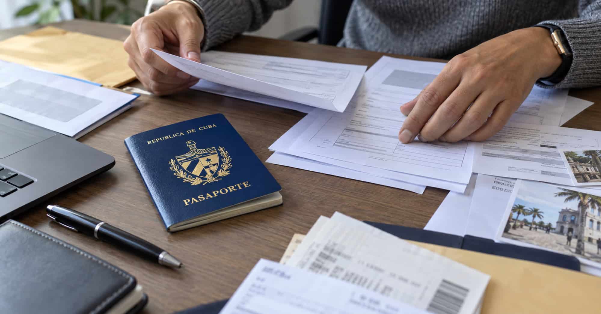 Persona organiza formularios consulares junto a un pasaporte cubano cerrado.