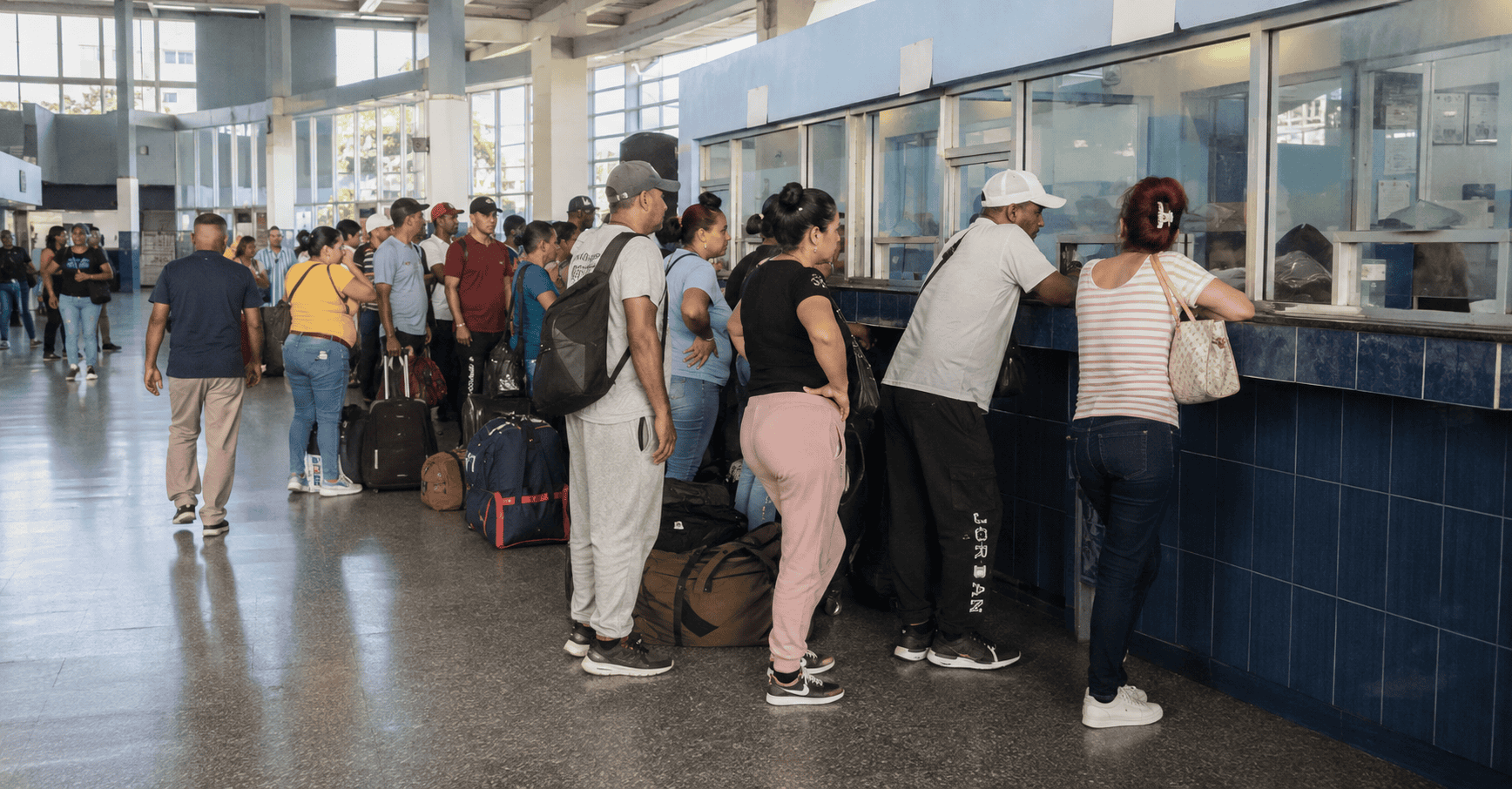 Viajeros esperando para comprar pasajes en una terminal de transporte interprovincial en Cuba.