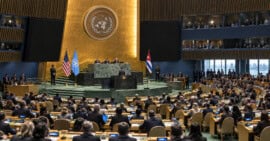 Orador visto a distancia ante delegaciones internacionales en un salón inspirado en la Asamblea General de la ONU.