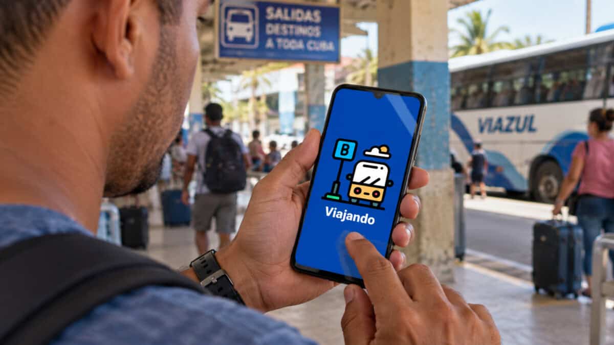 Cubano consulta el servicio online Viajando desde un teléfono celular en una terminal de transporte.